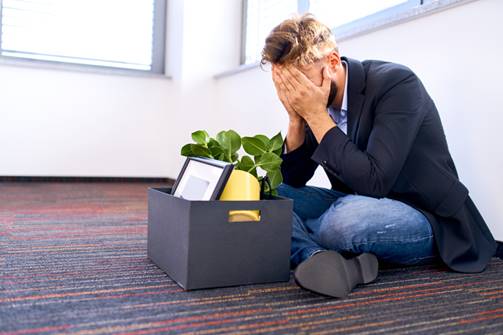 Man sitting with office packed, stressed - Wrongful Termination